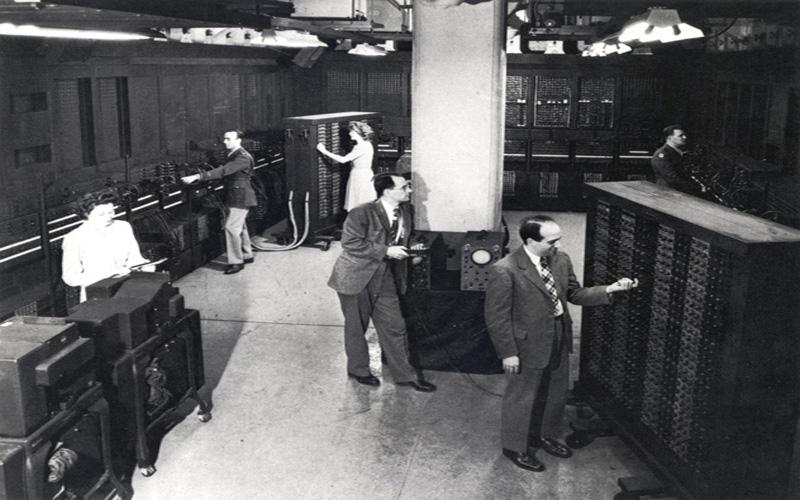 琼 & ENIAC共同发明者| 1946年ENIAC团队几名成员的集体形象. 左:ENIAC的共同发明者Presper Eckert和Homer Spence.  中间:ENIAC的共同发明人约翰Mauchly. 后中:琼 Jennings Bartik. 右:Herman Goldstine和露丝Lichterman(美国).S. 陆军照片(来自ARL技术图书馆档案)