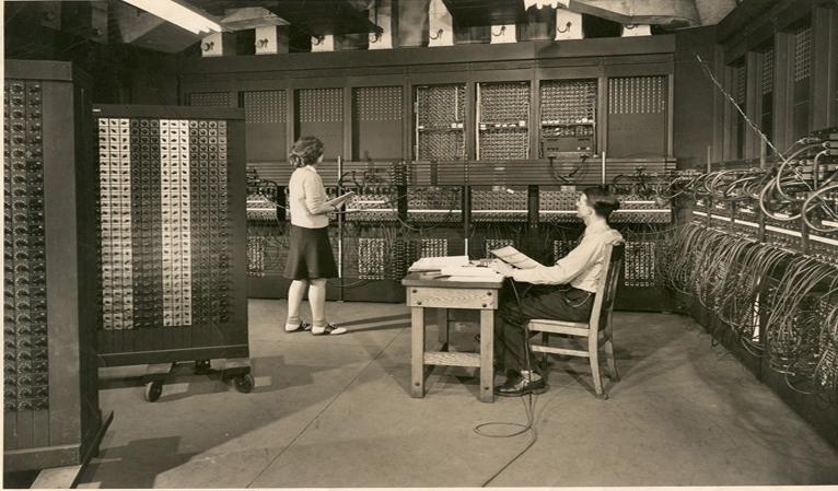 琼 & 艺术hur Burks | 琼在高级工程师艺术hur Burks的协助下设计ENIAC, 1946. (图片最初出现在1946年的《科学画报》上.  1946年，这幅画被送给了琼 Jennings Bartik, 2002年，她又(和她的侄女黛安·帕斯莫尔)把它送给了吉恩·詹宁斯·巴蒂克计算机博物馆. 巴提克博物馆拥有唯一已知的(在这个时候)现存的这幅图像的原始印刷品. 版权所有).