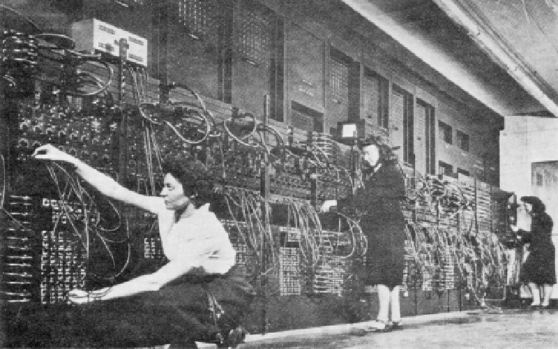 琼, Marlyn和Ruth程序ENIAC |左(后):琼 Jennings Bartik. 中:马林·威斯科夫.  右(跪地):露丝·利特曼. 琼 Jennings Bartik, Marlyn Wescoff和露丝Lichterman设计了ENIAC. (U.S. 陆军照片(来自ARL技术图书馆档案) 