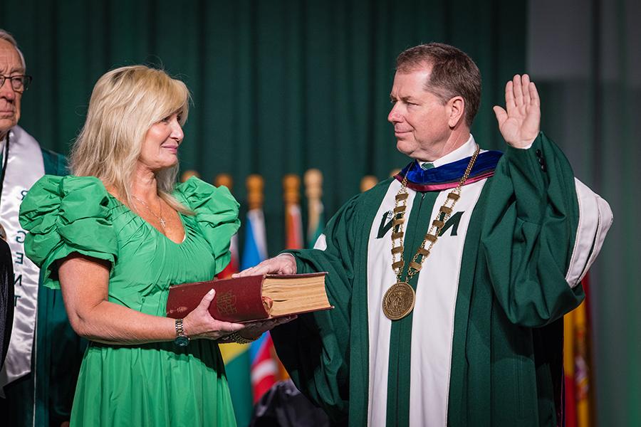 Placing his hand on a family Bible held by his wife, Jill, Dr. Lance Tatum accepted the charge to carry out the duties of Northwest’s president. (Photo by Todd Weddle/Northwest Missouri State University)